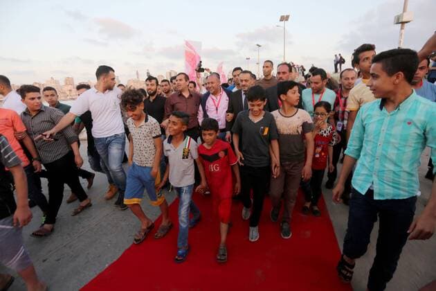 May 12, 2017 - Gaza City, Gaza Strip, Palestinian Territory - Palestinians walk on a red carpet during the 3rd Annual Red Carpet Festival for Human Rights Films at the Gaza seaport, on May 12, 2017. The Red Carpet Festival is held in the Gaza Strip this year for the third year in a raw, amid international and Arab attention. This year, the Hash-Tag of the festival will be Let s go back , which coincides with one hundred years for The Balfour Declaration, where the text of the Balfour Declaration is printed on the carpet Gaza City Palestinian Territory - ZUMAap3_ 20170512_zaf_ap3_027 Copyright: xMohammedxAsadx