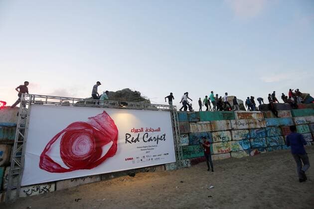 May 12, 2017 - Gaza City, Gaza Strip, Palestinian Territory - Palestinians climb on concrete blocks to watch the 3rd Annual Red Carpet Festival for Human Rights Films at the Gaza seaport, on May 12, 2017. The Red Carpet Festival is held in the Gaza Strip this year for the third year in a raw, amid international and Arab attention. This year, the Hash-Tag of the festival will be Let s go back , which coincides with one hundred years for The Balfour Declaration, where the text of the Balfour Declaration is printed on the carpet Gaza City Palestinian Territory - ZUMAap3_ 20170512_zaf_ap3_030 Copyright: xMohammedxAsadx