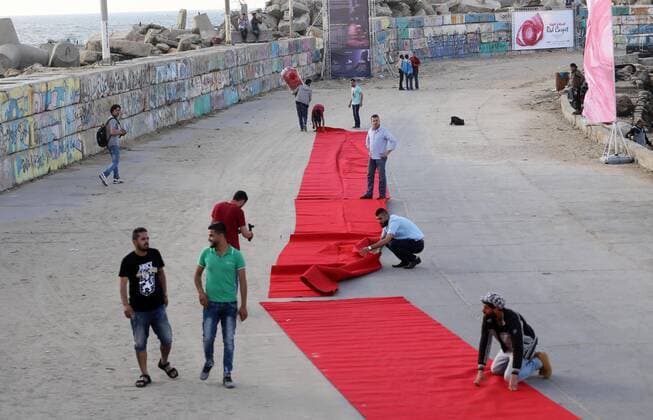 May 12, 2017 - Gaza City, Gaza Strip, Palestinian Territory - Palestinians place a red carpet during the 3rd Annual Red Carpet Festival for Human Rights Films at the Gaza seaport, on May 12, 2017. The Red Carpet Festival is held in the Gaza Strip this year for the third year in a raw, amid international and Arab attention. This year, the Hash-Tag of the festival will be Let s go back , which coincides with one hundred years for The Balfour Declaration, where the text of the Balfour Declaration is printed on the carpet Gaza City Palestinian Territory - ZUMAap3_ 20170512_zaf_ap3_031 Copyright: xMohammedxAsadx
