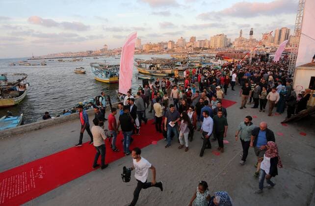 May 12, 2017 - Gaza City, Gaza Strip, Palestinian Territory - Palestinians walk on a red carpet during the 3rd Annual Red Carpet Festival for Human Rights Films at the Gaza seaport, on May 12, 2017. The Red Carpet Festival is held in the Gaza Strip this year for the third year in a raw, amid international and Arab attention. This year, the Hash-Tag of the festival will be Let s go back , which coincides with one hundred years for The Balfour Declaration, where the text of the Balfour Declaration is printed on the carpet Gaza City Palestinian Territory - ZUMAap3_ 20170512_zaf_ap3_037 Copyright: xMohammedxAsadx