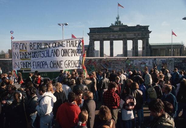 Menschen protestieren vor der Berliner Mauer fuer die Wiedervereinigung. Im Hintergrund das Brandenburger Tor. Berlin, 09.11.1989, Berlin Deutschland Copyright: xThomasxImox
