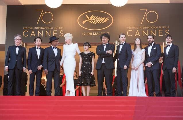 (170519) -- CANNES (FRANCE), May 19, 2017 -- Actors Byung Heebong, Steven Yeun, Giancarlo Esposito, Tilda Swinton and Ahn Seo-Hyun, director Bong Joon-Ho and actors Paul Dano, Lily Collins, Jake Gyllenhaal and Devon Bostic (From L to R) pose on the red carpet for the screening of the film Okja in competition at the 70th Cannes International Film Festival in Cannes, France, on May 19, 2017. ) FRANCE-CANNES-INTERNATIONAL FILM FESTIVAL-OKJA XuxJinquan
