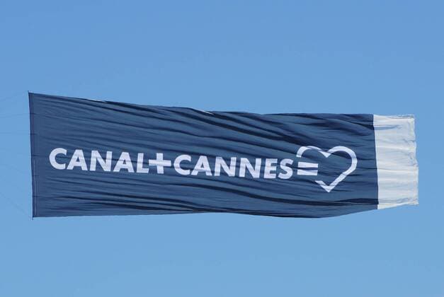 Flugzeugwerbung Canal+ in Cannes. Canal+ ist ein in Frankreich landesweit zu empfangender, boersennotierter Bezahlfernsehsender mit Sitz in Issy-les-Moulineaux, Departement Hauts-de-Seine. Er gehoert zur Groupe Canal+, welche wiederum 100-prozentige Tochter des Medienkonzerns Vivendi ist.