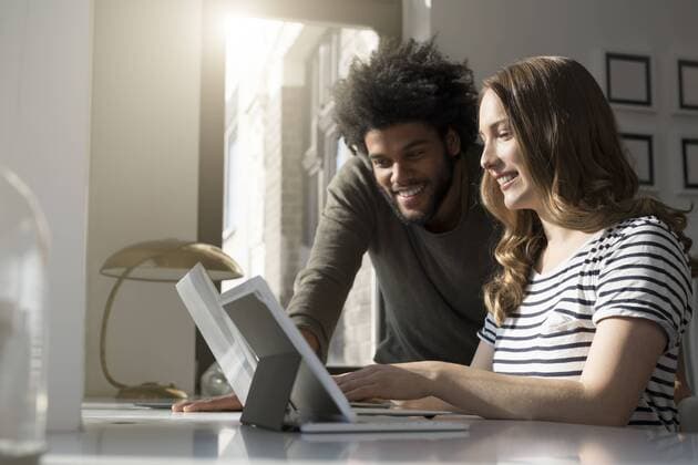 Smiling couple working at home with laptop and tablet model released Symbolfoto property released  SBOF00409