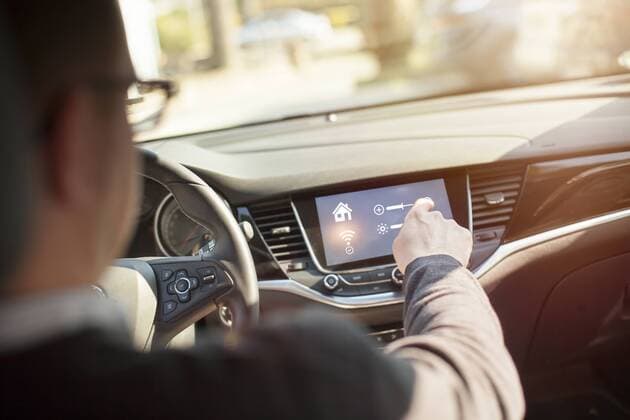 IMAGO Creative: Corporate: Klimaschutz, Digitalisierung und Urbanisierung Man in car adjusting devices at home via smartphone model released Symbolfoto property released  NAF00087