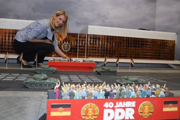 Bilder des Tages Anja Nitsch (General Managerin LitteBigCity) setzt die Figuren von Erich und Margot Honeker auf die Balustrade vor dem Palast der Republik Baustellenbegegnung mit Zeitzeugen der Geschichte Berlins zu Zeiten der Berliner Mauer einer geteilten Stadt, des ersten Litte Big City, die Mini-Figuren im Masstab 1:24, am Berliner Fernsehturm am Alex, am 14.06.2017