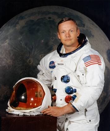 Portrait of Astronaut Neil A. Armstrong, commander of the Apollo 11 Lunar Landing mission in his space suit, with his helmet on the table in front of him. Behind him is a large photograph of the lunar surface.July 1, 1969 Hollywood CA USA  1003_201