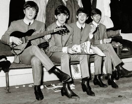The Beatles, John Lennon, George Harrison, Paul McCartney and Ringo Starr, sitting on a bench in matching gray suits, 1963. Hollywood CA USA  Copyright: xHAx 31386_790