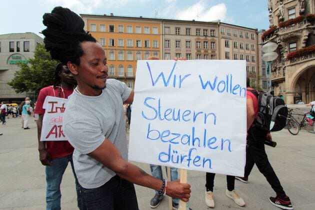 Demonstration gegen Abschiebungen an Schulen und Willkür der Behörden gegen Asylbewerber von verschiedenen Bürgerinitiativen auf dem Marienplatz in München, Bayern, Deutschland. Motto der Demo: Kampf jeder Abschiebung an unseren Schulen und überall. Auslöser waren die Vorkommnisse am 31.05.2017 1n einer Schule in Nürnberg, aus der die Polizei einen afghanischen Flüchtling entführen wollte, um ihn zurück ins Kriegsgebiet nach Afghanistan zu deportieren. Plakat mit Aufschrift wir wollen Steuern zahlen dürfen