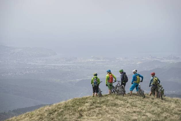 Mountain bikers looking at view while standing on top of mountain mit_2003_10515