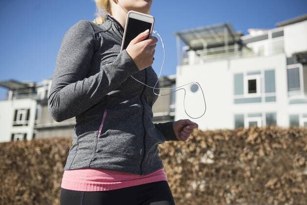 Woman jogging and listening music on smart phone mit_2032_10900