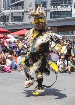 (170629) -- TORONTO, June 29, 2017 -- A performer(C) wearing men s traditional costume dances before the fashion show of the 2017 Aboriginal History Month Celebration at Yonge-Dundas Square in Toronto, Canada, June 28, 2017. ) (jmmn) CANADA-TORONTO-ABORIGINAL HISTORY MONTH-FASHION SHOW ZouxZheng 