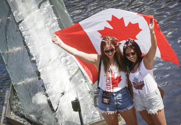 (170702) -- VANCOUVER, July 2, 2017 -- Two women pose for photos with a Canadian flag during the Canada Day celebration at Canada Place in Vancouver, Canada, July 1, 2017. People gathered at Canada Place in downtown Vancouver to celebrate the 150th anniversary of Canada on Saturday. ) (zxj) CANADA-VANCOUVER-CANADA DAY-CELEBRATION Liangxsen 
