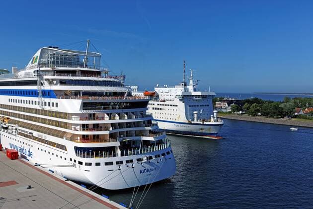 Fähre Tom Sawyer und Kreuzfahrtschiff AIDAdiva im Hafen von Rostock - Warnemünde. Die Kombifähre Tom Sawyer passiert in den Nachmittagsstunden des 18.06.2017 das Kreuzfahrtschiff AIDAdiva der Kreuzfahrtgesellschaft AIDA Cruises , welches im Hafen von Rostock - Warnemünde am Kreuzfahrtterminal liegt.