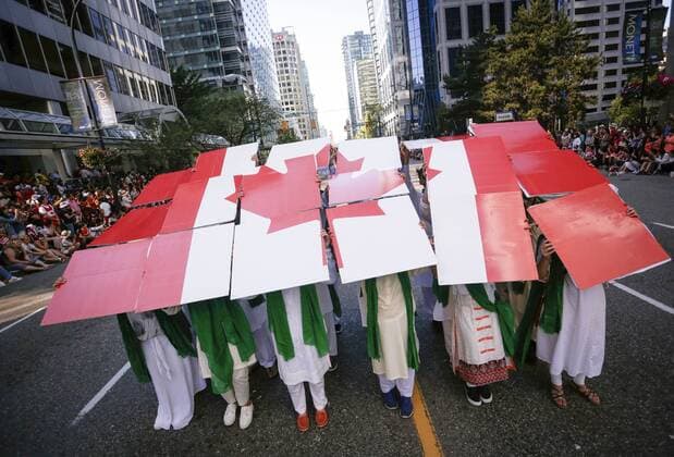 (170703) -- VANCOUVER, July 3, 2017 -- Performers hold a Canadian flag puzzle during the 2017 Canada Day Parade in Vancouver, Canada, July 2, 2017. About 2,000 participants in different traditional costumes participated in this event to celebrate Canada s 150th birthday on Saturday in Vancouver. ) (yy) CANADA-VANCOUVER-150TH CELEBRATION OF CANADA DAY LiangxSen 