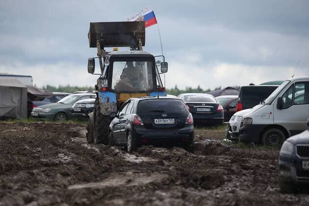 TVER REGION, RUSSIA â€“ JULY 9, 2017: A tractor pulls a car through mud at the 2017 Nashestvie open air rock music festival. Alexander Ryumin TASS  TS056AD6