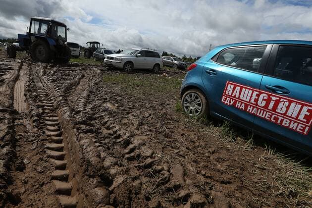 TVER REGION, RUSSIA â€“ JULY 9, 2017: A tractor pulls a car through mud at the 2017 Nashestvie open air rock music festival. Alexander Ryumin TASS  TS056AD8