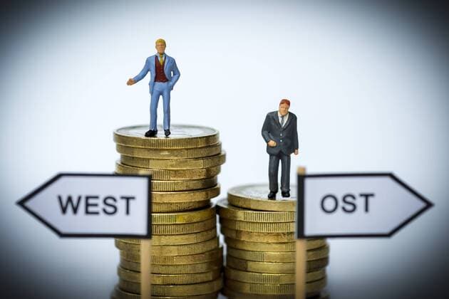 GeschÃ¤ftsmÃ¤nner-Miniaturfiguren auf MÃ¼nzstapeln, ungleiche GehÃ¤lter in West- und Ostdeutschland ** NUR FUER REDAKTIONELLE ZWECKE ** EDITORIAL USE ONLY **