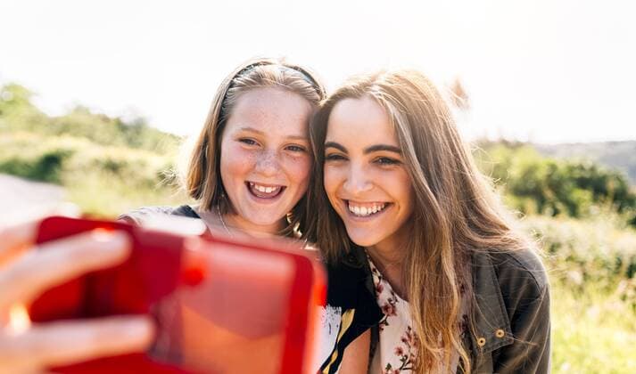 Two happy girls taking a selfie outdoors model released Symbolfoto  MGOF03428