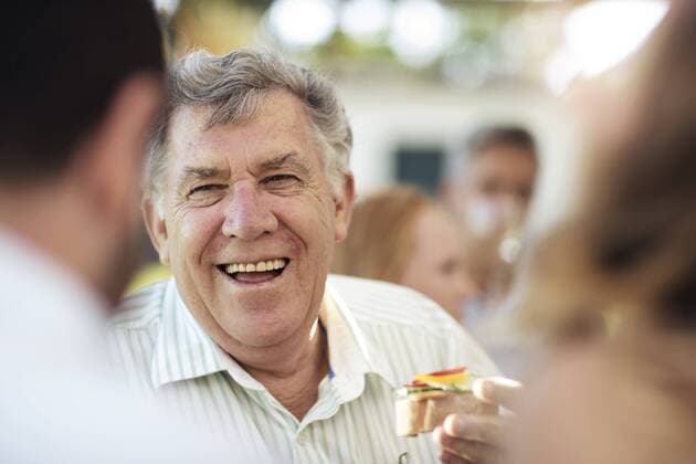 Happy senior man socializing on a garden party model released Symbolfoto property released  ZEF13981