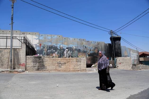 August 6, 2017 - Bethlehem, West Bank, Palestinian Territory - A Palestinian woman walks past a graffiti depicting US President Donald Trump on the controversial Israeli separation barrier in the West Bank town of Bethlehem on August 8, 2017 Bethlehem Palestinian Territory - ZUMAap3_ 20170806_zaf_ap3_032 Copyright: xShadixHatemx