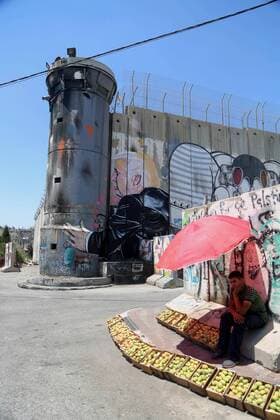 August 6, 2017 - Bethlehem, West Bank, Palestinian Territory - A Palestinian vendor sells vegetables in front of a graffiti depicting US President Donald Trump on the controversial Israeli separation barrier in the West Bank town of Bethlehem on August 8, 2017 Bethlehem Palestinian Territory - ZUMAap3_ 20170806_zaf_ap3_043 Copyright: xShadixHatemx