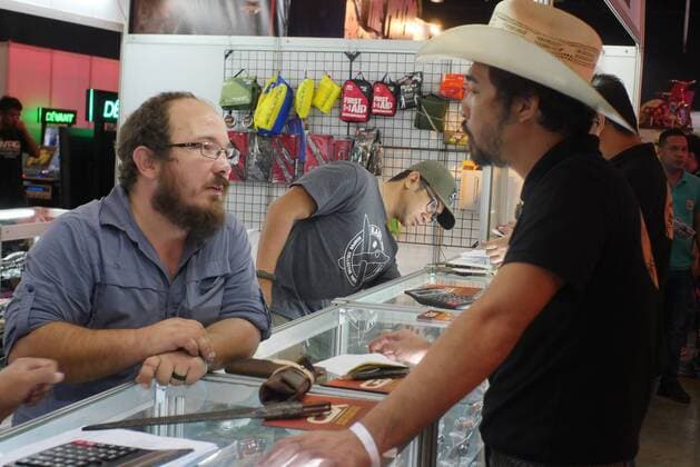 Philippines: HistoryCon 2017 A seller of bladed weapons and craftsmanship answering the inquiry of this potential buyer.  GeorgexBuid