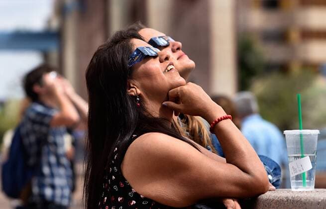 August 21, 2017 - Albuquerque, NM, U.S. - 2017---Lisa Rodriguez, front and Rachel Williams, back, watch Monday s solar eclipse on Civic Plaza in downtown Albuquerque, photographed on Monday August 21, 2017. Albuquerque U.S. - ZUMAab1_ 20170821_zaf_ab1_005 Copyright: xDeanxHanson AlbuquerquexJournalx