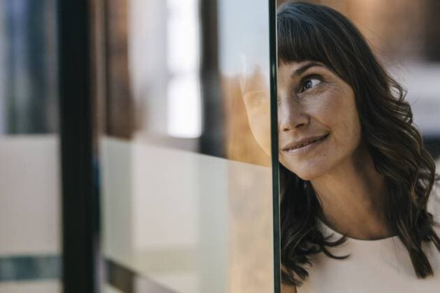 IMAGO Creative: Corporate: Klimaschutz, Digitalisierung und Urbanisierung Portrait of a businesswoman looking through glass pane model released Symbolfoto property released  KNSF01988