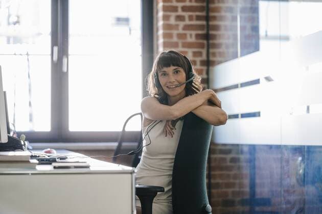 Woman sitting in office, wearing headset model released Symbolfoto property released  KNSF02081