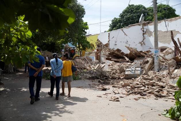 (170909) -- OAXACA (MEXICO), Sept. 9, 2017 -- Residents walk past collapsed building after an earthquake in Oaxaca state, Mexico, on Sept. 8, 2017. A powerful earthquake measuring 8.2 on the Richter scale struck off Mexico s southern coast late Thursday night, killing at least 61 people. ) MEXICO-OAXACA-EARTHQUAKE-AFTERMATH DanxHang 