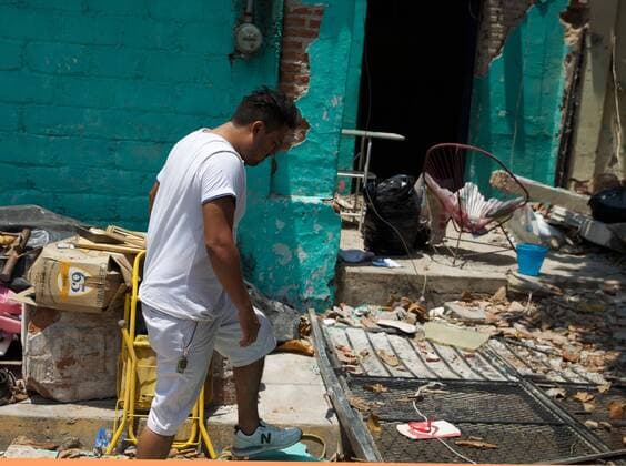 (170910) -- JUCHITAN (MEXICO), Sept. 10, 2017 -- A local resident walks past a damaged house after an earthquake hit in Juchitan, Oaxaca state, Mexico, Sept. 9, 2017. A powerful earthquake measuring 8.2 on the Richter scale struck off Mexico s southern coast late Thursday night, killing 90 people. ) MEXICO-OAXACA-JUCHITAN-EARTHQUAKE DanxHang 