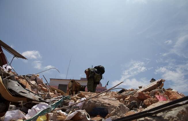 (170910) -- JUCHITAN (MEXICO), Sept. 10, 2017 -- A rescue worker and his dog search at the building collapse site after an earthquake hit in Juchitan, Oaxaca state, Mexico, Sept. 9, 2017. A powerful earthquake measuring 8.2 on the Richter scale struck off Mexico s southern coast late Thursday night, killing 90 people. ) MEXICO-OAXACA-JUCHITAN-EARTHQUAKE DanxHang 