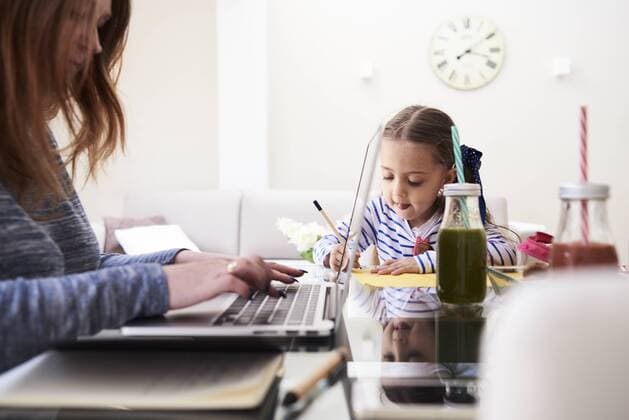 Little girl drawing with pencil at table beside her mother typing on keyboard of laptop model released Symbolfoto property released  IGGF00011