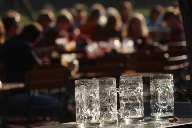 spätsommerliche Temperatures and Favourite Sunshine enticed many Sun in the Beer garden royal Hirsch garden in Munich Bavaria Germany Geleerte Mass Beer in Gegenlicht the Afternoon sun