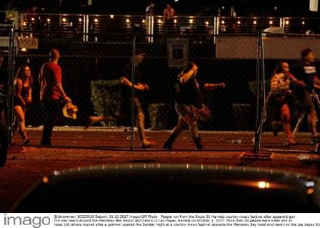 People run from the Route 91 Harvest country music festival after apparent gun fire was heard around the Mandalay Bay Resort and Casino in Las Vegas, Nevada on October 1, 2017. More than 20 people were killed and at least 100 others injured after a gunman opened fire Sunday night at a country music festival opposite the Mandalay Bay hotel and resort on the Las Vegas Strip, authorities said.  LAV2017100202 JAMESxATOA