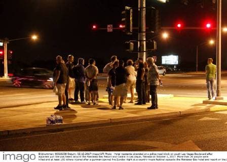 Hotel residents stranded at a police road block on south Las Vegas Boulevard after apparent gun fire was heard around the Mandalay Bay Resort and Casino in Las Vegas, Nevada on October 1, 2017. More than 20 people were killed and at least 100 others injured after a gunman opened fire Sunday night at a country music festival opposite the Mandalay Bay hotel and resort on the Las Vegas Strip, authorities said.  LAV2017100213 JAMESxATOA