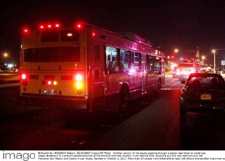 Another convoy of city buses passing through a police road block on south Las Vegas Boulevard to transport people stranded at the Route 91 Harvest country music festival after apparent gun fire was heard around the Mandalay Bay Resort and Casino in Las Vegas, Nevada on October 1, 2017. More than 20 people were killed and at least 100 others injured after a gunman opened fire Sunday night at a country music festival opposite the Mandalay Bay hotel and resort on the Las Vegas Strip, authorities said.  LAV2017100219 JAMESxATOA