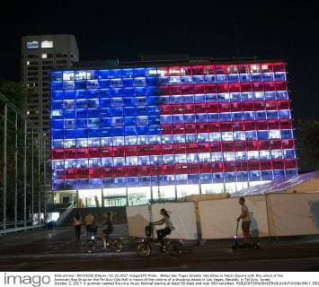 Bilder des Tages Israelis ride bikes in Rabin Square with the colors of the American flag lit up on the Tel Aviv City Hall in honor of the victims of a shooting attack in Las Vegas, Nevada, in Tel Aviv, Israel, October 2, 2017. A gunman opened fire on a music festival leaving at least 58 dead and over 500 wounded.  JER2017100221 DEBBIExHILL