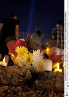 The light beam from the Luxor hotel shines above mourners gathered at a candlelight vigil along south Las Vegas Boulevard for victims of the shooting at the Route 91 Harvest country music festival in Las Vegas, Nevada on October 2, 2017.  LAV2017100250 JAMESxATOA