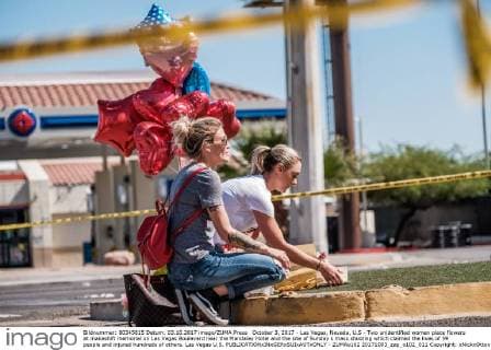 October 3, 2017 - Las Vegas, Nevada, U.S - Two unidentified women place flowers at makeshift memorial on Las Vegas Boulevard near the Mandalay Hotel and the site of Sunday s mass shooting which claimed the lives of 59 people and injured hundreds of others. Las Vegas U.S. - ZUMAo102 20171003_zap_o102_011 Copyright: xNickxOttox