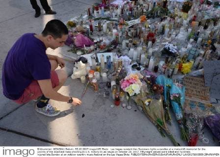 Las Vegas resident Ken Summers lights a candles at a makeshift memorial for the victims of the deadliest mass shooting in U.S. history in Las Vegas on October 23, 2017. Fifty-eight people were killed and hundreds injured late Sunday at an outdoor country music festival on the Las Vegas Strip.  LAV20171003800 JIMxRUYMEN