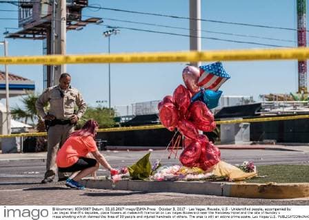 October 3, 2017 - Las Vegas, Nevada, U.S - Unidentified people, accompanied by Las Vegas Sheriff s deputies, place flowers at makeshift memorial on Las Vegas Boulevard near the Mandalay Hotel and the site of Sunday s mass shooting which claimed the lives of 59 people and injured hundreds of others. The area is still an active crime scene. Las Vegas U.S. - ZUMAo102 20171003_zap_o102_029 Copyright: xNickxOttox