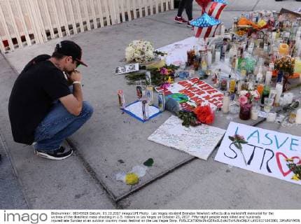 Las Vegas resident Brandon Newhart reflects at a makeshift memorial for the victims of the deadliest mass shooting in U.S. history in Las Vegas on October 23, 2017. Fifty-eight people were killed and hundreds injured late Sunday at an outdoor country music festival on the Las Vegas Strip.  LAV20171003801 JIMxRUYMEN