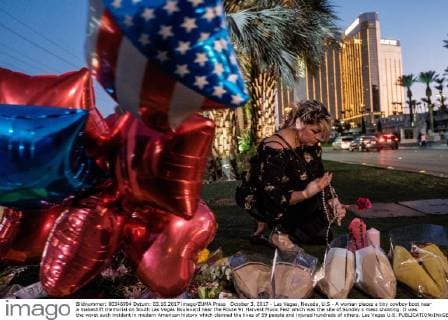 October 3, 2017 - Las Vegas, Nevada, U.S - A woman places a tiny cowboy boot near a makeshift memorial on South Las Vegas Boulevard near the Route 91 Harvest Music Fest which was the site of Sunday s mass shooting. It was the worst such incident in modern American history which claimed the lives of 59 people and injured hundreds of others. Las Vegas U.S. - ZUMAo102 20171003_zap_o102_054 Copyright: xNickxOttox