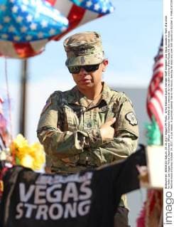 Army National Guard member Staff Sergeant Lisa Insua pauses in front of a cross for fallen Las Vegas Police Department Officer Charleston Hartfield at a memorial for the slain victims of the Route 91 Harvest music festival mass shooting October 19, 2017, in Las Vegas. A gunman opened fire on the music, leaving 58 dead and over 500 injured on October 1.  LAV20171019002 RONDAxCHURCHILL
