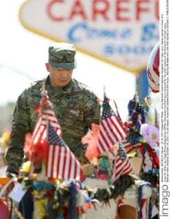 Army National Guard member Sergeant 1st Class Larry Harlan pauses in front of a cross for fallen Las Vegas Police Department Officer Charleston Hartfield at a memorial for the slain victims of the Route 91 Harvest music festival mass shooting October 19, 2017, in Las Vegas. A gunman opened fire on the music, leaving 58 dead and over 500 injured on October 1.  LAV20171019004 RONDAxCHURCHILL