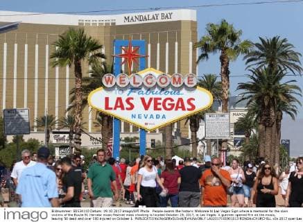 People swarm the historic Welcome to Las Vegas Sign where a memorial for the slain victims of the Route 91 Harvest music festival mass shooting is located October 19, 2017, in Las Vegas. A gunman opened fire on the music, leaving 58 dead and over 500 injured on October 1.  LAV2017101901013 RONDAxCHURCHILL
