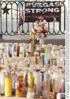 A poster hangs on the fence near a sea of candles at a roadside memorial for the slain victims of the Route 91 Harvest music festival mass shooting near the historic Welcome to Las Vegas sign October 19, 2017, in Las Vegas. A gunman opened fire on the music, leaving 58 dead and over 500 injured on October 1.  LAV20171019017 RONDAxCHURCHILL