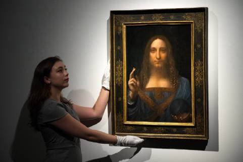 October 24, 2017 - London,UK - A Christies staff member holds a painting titled Salvator Mundi (1490) by artist Leonardo da Vinci. The painting of Christ as Salvator Mundi was recently attributed to Leonardo da Vinci, who is known to have painted the subject. It was lost and later rediscovered, and restored and exhibited in 2011. London UK  - ZUMAt138 20171024_zap_t138_005 Copyright: xRayxTangx